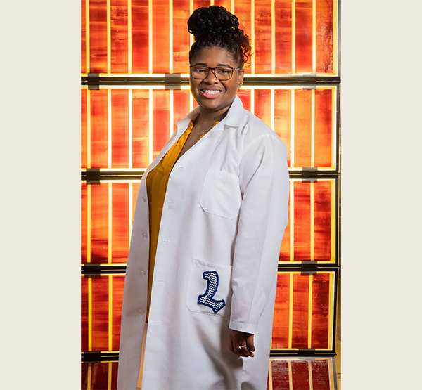Engineer Lyndsey McMillon-Brown stands in front of solar cells at NASA’s Glenn Research Center (photo courtesy of Lyndsey McMillon-Brown).